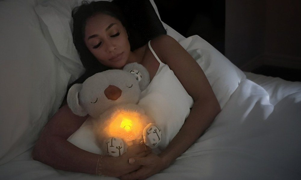 Parent asleep holding the Froplay Koala Calm Buddy with its nightlight glowing