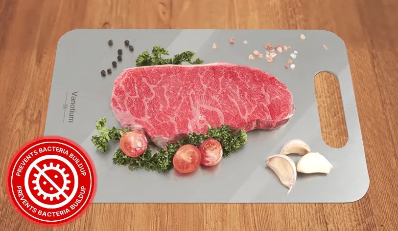 Raw steak, tomatoes and garlic prepared on a Vanotium titanium cutting board